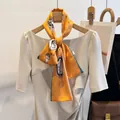 Détail rapproché d'un foulard en soie orange à motif paisley stylisé en tour de cou - Jaune Éventail / 150cm