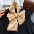 Vue détaillée d'un élégant foulard fin avec motif floral noué en un nœud papillon - Café Malte / 150cm