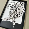 Elegant white silk-like scarf with black line pattern and pearl magnetic buckle - Camellia