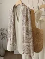 Elegant bohemian paisley print scarf with tassels displayed on a wooden hanger - 180cm / Light Coffee Paisley