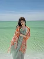 Lightweight orange floral printed shawl with tassels worn by a woman at the beach - 180cm / Setting Sun