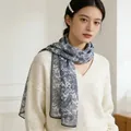 Elegant long silk scarf for women featuring a blue vintage floral pattern on white mesh. - Celadon Paisley