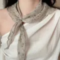 Close-up detail of 100% linen floral print scarf tied as a necktie in retro Japanese style. - Linen Triangle Scarf / Natural Small Floral