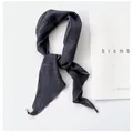 Close-up detail showing the texture of charcoal grey ramie linen skinny scarf knotted on white - 110cm / Navy Blue
