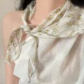 Close-up detail of a retro floral linen scarf tied gracefully around the neck. - Linen Triangle Scarf / Yellow Botanical Floral