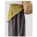 Close-up detail view of a yellow linen triangle scarf with patterns styled on a dark skirt - Yellow Parallel Lines Print