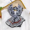Indigo paisley silk scarf 35x140 with geometric pattern borders shown on a hanger - Greek Key