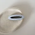 Detail van een lichtblauwe stoffen BB-haarclip met stippen op een beige keramische schaal. - Holle Ovale Clip / Blauwe Stippen