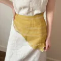 Detailed macro view of a vintage yellow linen floral wrap styled over a beige dress. - Linen Triangle Scarf / Yellow Botanical Striped