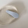 Detailopname van een lichtblauwe stoffen haarclip met rode stippen op stenen ondergrond - Waterdruppel BB Clip / Blauwe Stippen