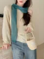 Detailed shot of a stylish teal linen scarf paired with a beige knit sweater and jeans - Long Style / 175cm / Teal