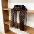 Elegant black silk scarf with vibrant orange polka dots draped on a wooden shelf - Brown Orange Polka Dot