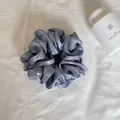 Gedetailleerde close-up van de parelmoer satijnen textuur van een grijze haarelastiek - Parelblauw