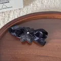 Macro detail of a black multi-layered ribbon bow hair clip featuring a cute bear design - Black Bear Style (FJ160) / Black Bear Hair Clip