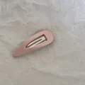 Gros plan d'une barrette à cheveux BB recouverte de tissu rose sur du papier blanc plissé - Goutte d'Eau Évidée / Rose
