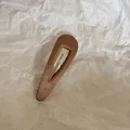 Barrette à cheveux BB minimaliste en tissu marron sur fond de papier blanc texturé - Goutte d'Eau Évidée / Marron