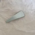 Détail d'une barrette à cheveux minimaliste en tissu bleu clair sur papier texturé - Triangulaire / Bleu