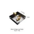 Modern silver stainless steel square napkin holder featuring golden ginkgo leaf weights - Silver Ginkgo Leaf Style