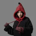 Close-up of a red knit balaclava with pom-pom and matching plaid mittens on model. - Red
