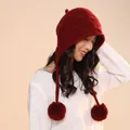 Close-up of a red wool knit elf hat with cute hanging pom-poms and textured knit pattern - One Size / Red