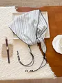 Primo piano di un foulard triangolare vintage a righe con lacci e perline decorative - Gessato bianco