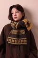 Detailed view of Fair Isle snowflake wool blend scarf in brown and yellow worn by model - 170cm / Yellow Khaki