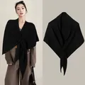 Elegant black wool blend cross-knit shawl cape shown on model and in a flat lay view - Black