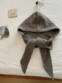 Vista dettagliata di un passamontagna in maglia grigia calda su un lenzuolo bianco. - colore moka