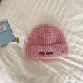 Macro view showing the soft texture and 'Hello Kele' embroidery on pink beanie - One Size / Light Pink