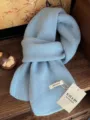 Detailaufnahme eines hellblauen Strickschals aus 100% Wolle mit handgefertigten Etiketten - Mittellanger Stil / Himmelblau