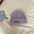Macro view of lavender knit beanie with HelloKele embroidery on soft textured fabric - One Size / Light Purple