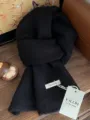 Detailansicht eines hochwertigen Strickschals aus 100 % Wolle mit weicher Textur - Mittellanger Stil / Schwarz