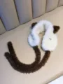 Detail of cute cat ear earmuffs with soft white and brown plush texture and ties. - One Size / White
