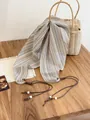 Detail of vintage striped triangular scarf with beaded drawstring on a wooden table. - Beige Colorful Striped