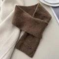 Detail view showing the soft texture of a brown crossed knitted scarf with a metal tag - Criss Cross Halter / Brown