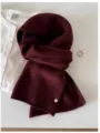 Close-up of premium burgundy 100% wool knitted scarf showing fine texture and metal tag - 144cm / Hawthorn Red