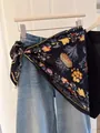 Chic floral print silk triangle scarf used as a stylish waist belt accessory. - Black Floral