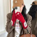 Red knitted gloves with white lace trim and Mulanduo label in a mirror selfie view. - One Size / Red