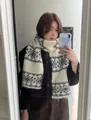 Close-up detail of the vintage snowflake jacquard pattern on a soft knit winter scarf - Black and White