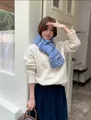 Model wearing blue snowflake knitted scarf in a soft winter outfit - Blue