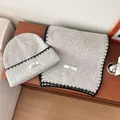Dettaglio del set cappello e sciarpa in maglia grigia con bordi a punto coperta. - Set da 2 pezzi cappello e sciarpa / Grigio chiaro