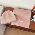 Accogliente set berretto e sciarpa in maglia rosa elegantemente esposto su un tavolo in legno - Set da 2 pezzi cappello e sciarpa / Rosa