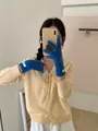 Close-up of stylish blue merino wool knitted gloves worn by a female model for winter - One Size / Blue