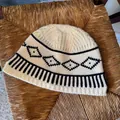 Dettaglio di un berretto in maglia crema con motivi a rombi neri in stile Fair Isle. - Taglia unica / Bianco