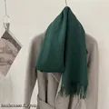 Detailed view of a premium green 100% wool scarf with elegant fringe on a coat - Forest Green / 185cm