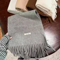 Vista detallada de una bufanda de mezcla de lana gris con flecos y etiqueta de material - 200cm / Gris Texturizado