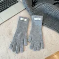Detail shot of grey 100% merino wool gloves with a small white woven label - One Size / Gray