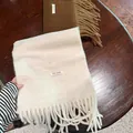 Bufanda suave de mezcla de lana con flecos y etiqueta de material sobre mesa de madera - 200cm / Blanco Almendra