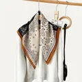 Close-up of a paisley print cotton linen square scarf draped over a white sweatshirt. - RZ6539-Black