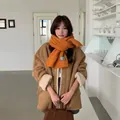 Soft orange knitted scarf for winter cozy style worn by a model in lifestyle setting. - 174*35 / Pumpkin Orange